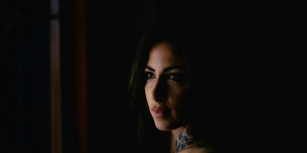 a woman with a tattoo on her chest in the dark